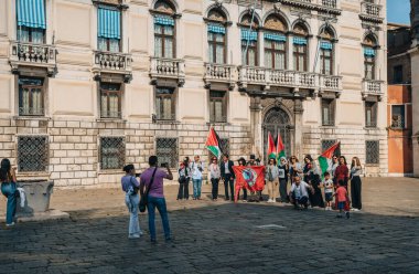 Venedik, İtalya - 21 Mayıs 2022: Partito Komünist Partisi 'nin (Komünist Parti) Venedik' in başkenti Campo San Geremia Meydanı 'nda Özgür Filistin' i destekleyen fotoğraflarını çeken turistler.