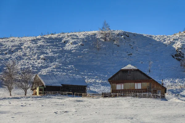 Casa rústica en un campo cubierto de nieve —  Fotos de Stock