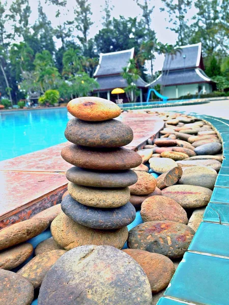 Junto a la piscina azul, piedra apilada Imágenes de stock libres de derechos