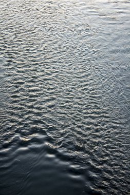 Güzel su yüzeyi arka planı. Gün batımında bir nehir manzarası.