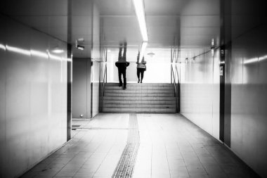 Tavana yansıyan insan siluetlerinin olduğu bir yeraltı geçidi..