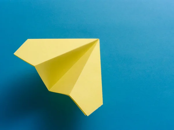 蓝色背景的黄色折纸战斗机 — 图库照片