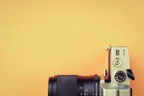 Turuncu zemin üzerinde eski 35 mm slr film kamerası metin için boş kopyalama yapıştırıcı alanı.