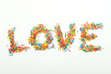 Minimalist konsept düz yerde şeker serpintilerinden yapılmış aşk yatıyor.