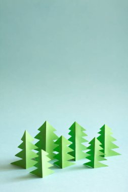Paper forest with free copy paste space for text. Green paper trees on blue background.