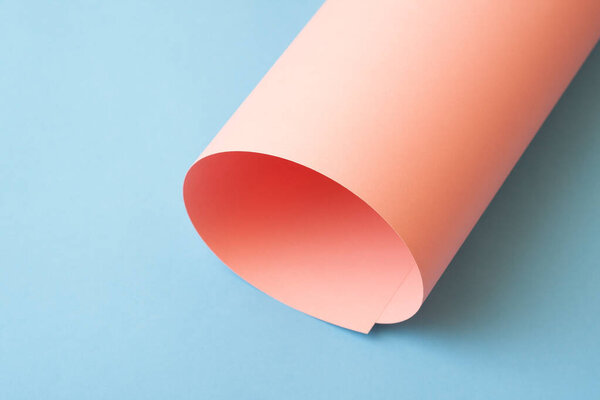 Rolled pink paper on blue background.