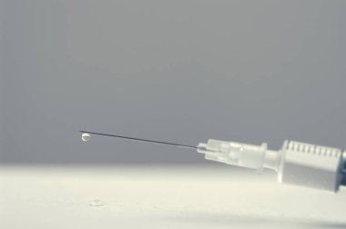 İğne üzerinde damlası olan bir şırınganın monokrom görüntüsünü kapat
