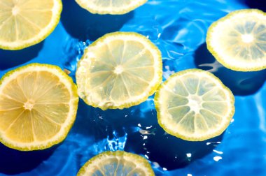 Mavi arka planda limon dilimleri. Yüzen limon dilimleri arka plan.