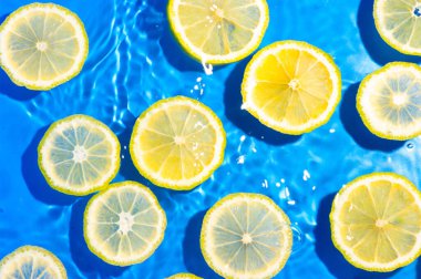 Mavi arka planda limon dilimleri. Yüzen limon dilimleri arka plan.