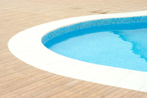 Swimming pool with clean blue water under the bright sunlight.