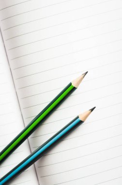 Yeşil ve mavi kalemli defter kağıtlarını aç.