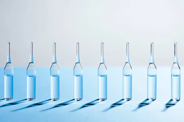 Group Glass Ampules Standing Row Blue Background — Stock fotografie