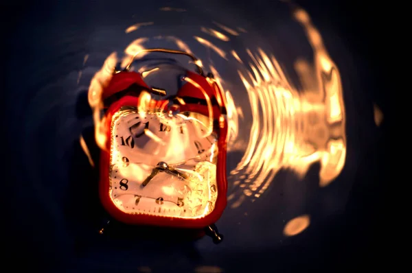 Blurry Abstract Composition Drowning Alarm Clock Ripples Fire Reflected Water — Stockfoto