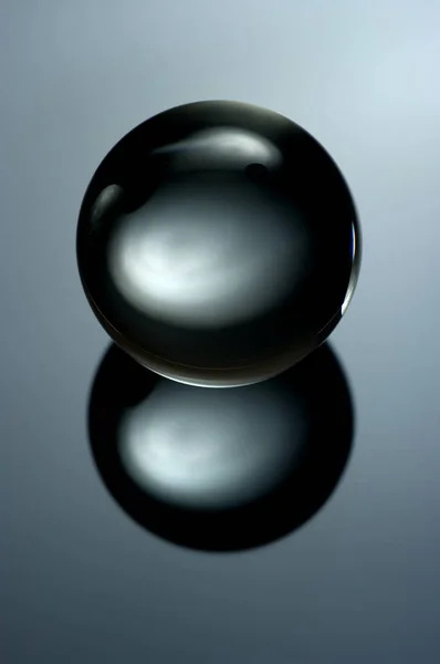 Abstract still life image of a glass ball in a low key. Geometric object with reflection, Glass sphere in a low key.