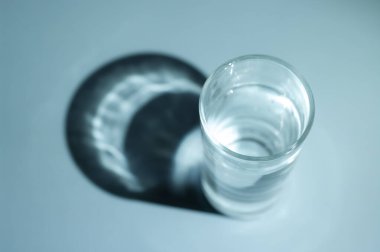 Glass of water with dark shadow