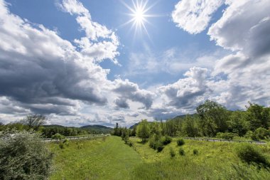 Adirondacks 'da yaz sahnesi. Güneşi çevreleyen bulutlar.