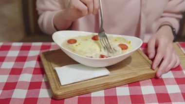 Bir kadın peynir ve krema sosunun altında hindi ya da tavuk filetosu ile sıcak jülyen yer.. 