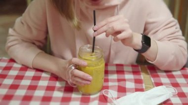 Güzel bir kadın akşamları kafede oturmuş cam bardakta sıcak deniz dikenli vitamin çayı içiyor.. 
