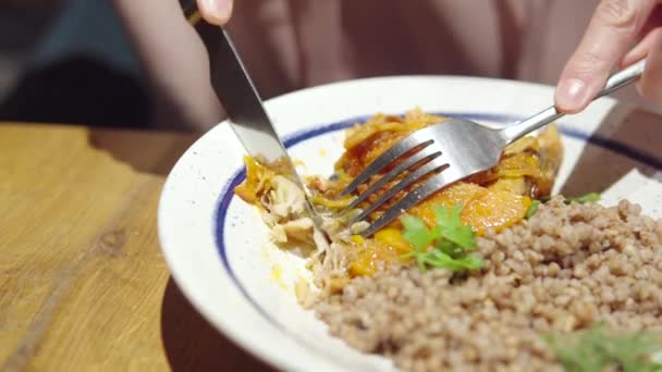 Pengunjung restoran makan ikan yang dipanggang atau direbus dengan sayuran dan buckwheat bubur. — Stok Video