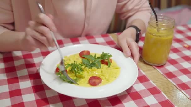 Жінка їсть апетитні гарбузові макарони з соусом, креветками, вишневими помідорами та базиліком . — стокове відео