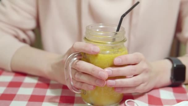Frau Wärmt Ihre Hände Einem Sanddorn Vitamintee Durch Einen Glasbecher — Stockvideo