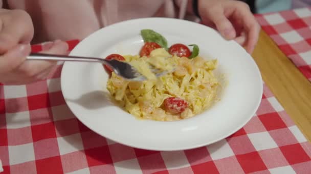 Mujer comiendo pasta de calabaza italiana con camarones, salsa, tomates y albahaca en un restaurante italiano. — Vídeos de Stock