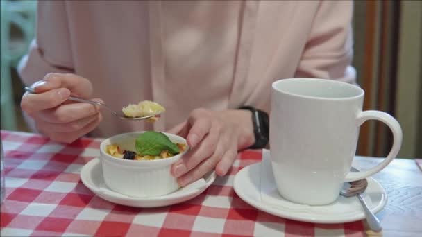 Chica vegetariana comiendo pudín de manzana, bebiendo té en un café. — Vídeo de stock