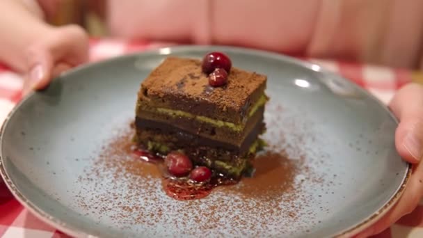 Selektivt fokus för Matcha grönt te lager tårta toppad med kakao och körsbär bär. — Stockvideo