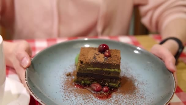 Demonstration av matcha grönt te lager tårta toppad med en mörk choklad. — Stockvideo