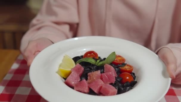 Délicieuses pâtes noires à l'encre de seiche, thon cru et légumes. — Video