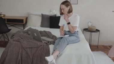 Bilgisayara bakan genç bir öğrenci evden ders çalışıyor.. 