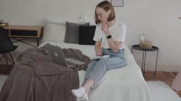 Estudiante joven mirando el ordenador portátil estudiando desde casa. — Vídeos de Stock