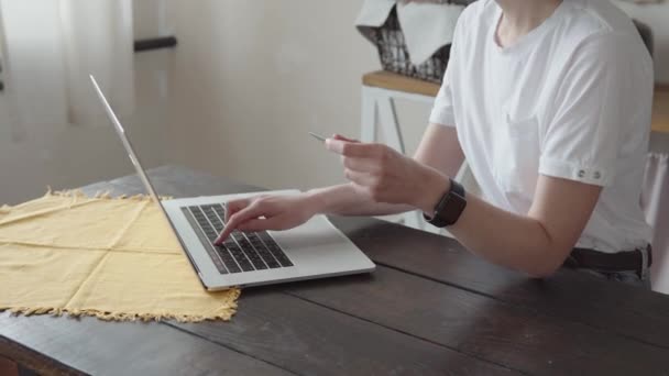 Gros plan d'une jeune femme d'affaires détenant une carte de crédit et utilisant un ordinateur portable. — Video