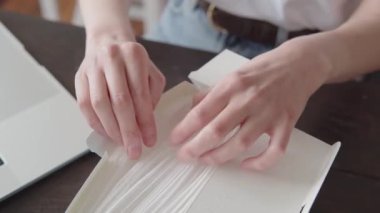 Bir kadının yakın plan çekimi, tek kullanımlık tıbbi bir steril maskeyi yığından alır.. 