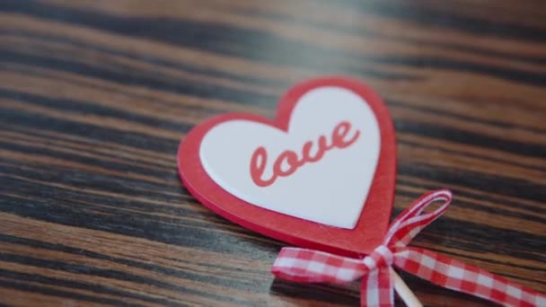 Décor fait à la main pour la Saint-Valentin sur la table vue rapprochée. Cadeau sous la forme d'un cœur comme symbole d'amour. Le concept de vacances d'amour, de préparation à un mariage ou à un anniversaire. — Video