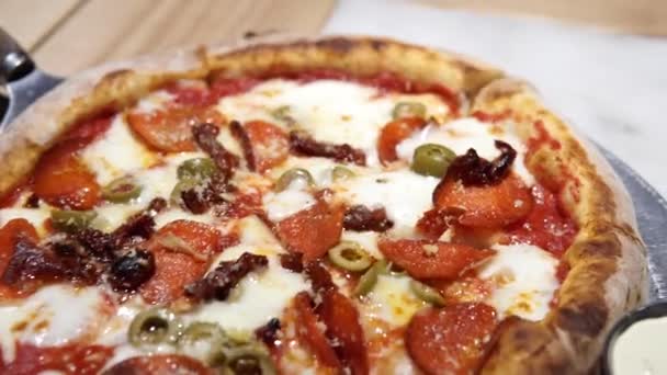 Închiderea unei pizza gustoasă cu pepperoni fierbinte pe farfurie în restaurant. — Videoclip de stoc