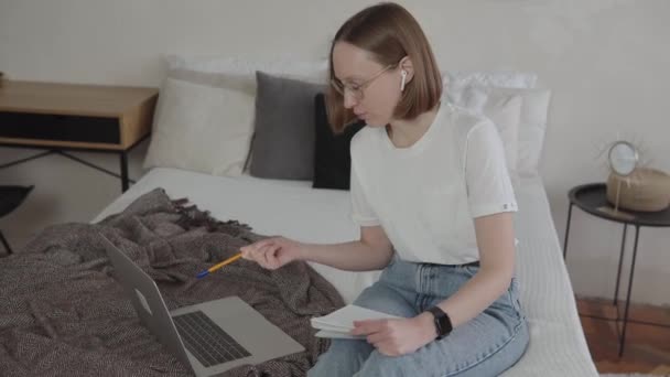 Jonge Kaukasische vrouw op zoek naar laptop studeren vanuit huis. — Stockvideo