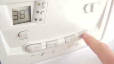 Parmak, sıcak su ve ısıtma için gaz kazanının ısısını ayarla.. 