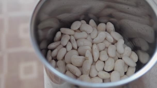 Haricots blancs dans une casserole d'eau sur la table de cuisine. — Video
