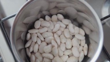 Mutfaktaki bir tencerede beyaz fasulye. Yavaş çekim.