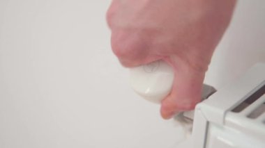 Bir kadının eli akünün sıcaklığını sıcaklık kontrolörüyle ayarlar. Ev ısıtma sistemi. 