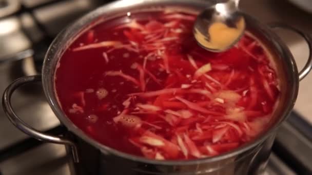 Cozinheiro coleta espuma de borsch - sopa de beterraba ucraniana tradicional. — Vídeo de Stock