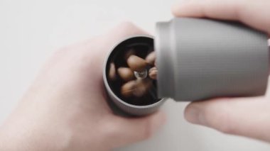 Bir adam kahve öğütücüsünü taze kavrulmuş Arabika kaliteli kahve çekirdekleri ile dolduruyor.. 