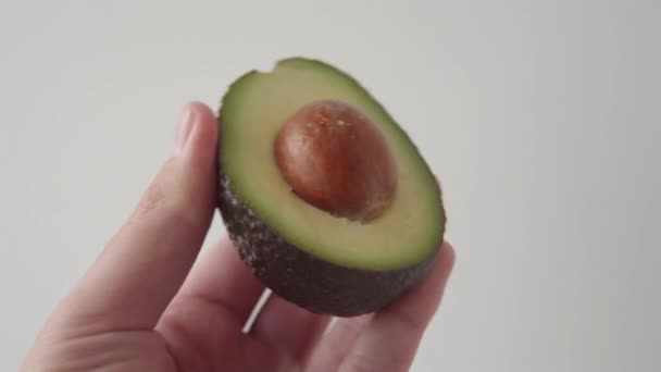 Male Hand Holding Sliced Half Fresh Juicy Avocado Bone White — Stock Video