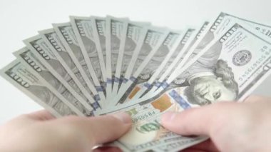 Adamın biri 100 Amerikan doları hayranı. Beyaz arka planda nakit para. Döviz bürosu. Rüşvet ve yolsuzluk kavramı. Finans ve yatırım.