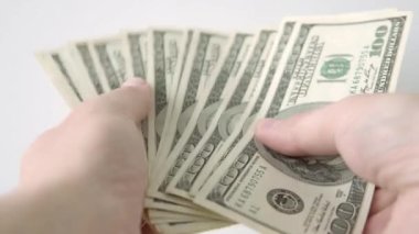 Bir adam yığınla para sayıyor, 100 dolarlık banknotlar, banknotların hayranı. Başarı, vergiler, finans, tasarruf, yatırım konsepti. Yakın çekim..