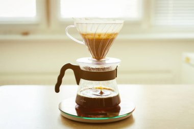Morning coffee, alternative method of making coffee in a glass drip decanter. Japanese process of brewing a coffee drink in a paper filter. clipart