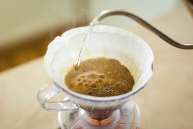 Sürahinin üzerine v60 damlası dök, alternatif kahve yapma yöntemi. Kahve yatağında hava kabarcıkları..