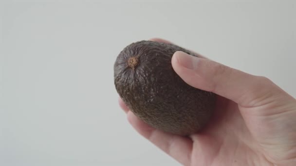 Mano Sosteniendo Aguacate Fresco Jugoso Sobre Fondo Blanco Imágenes Primer — Vídeo de stock