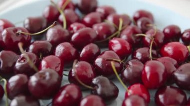 Mavi bir tabakta bir sürü taze kiraz. Taze bahar meyveleri, çiftlik hasadı. Yakın görünüm..